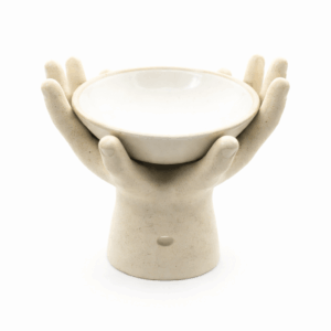 Crème keramieken aromabrander in handvorm met rond schaaltje bovenop, vrijstaand op witte achtergrond.