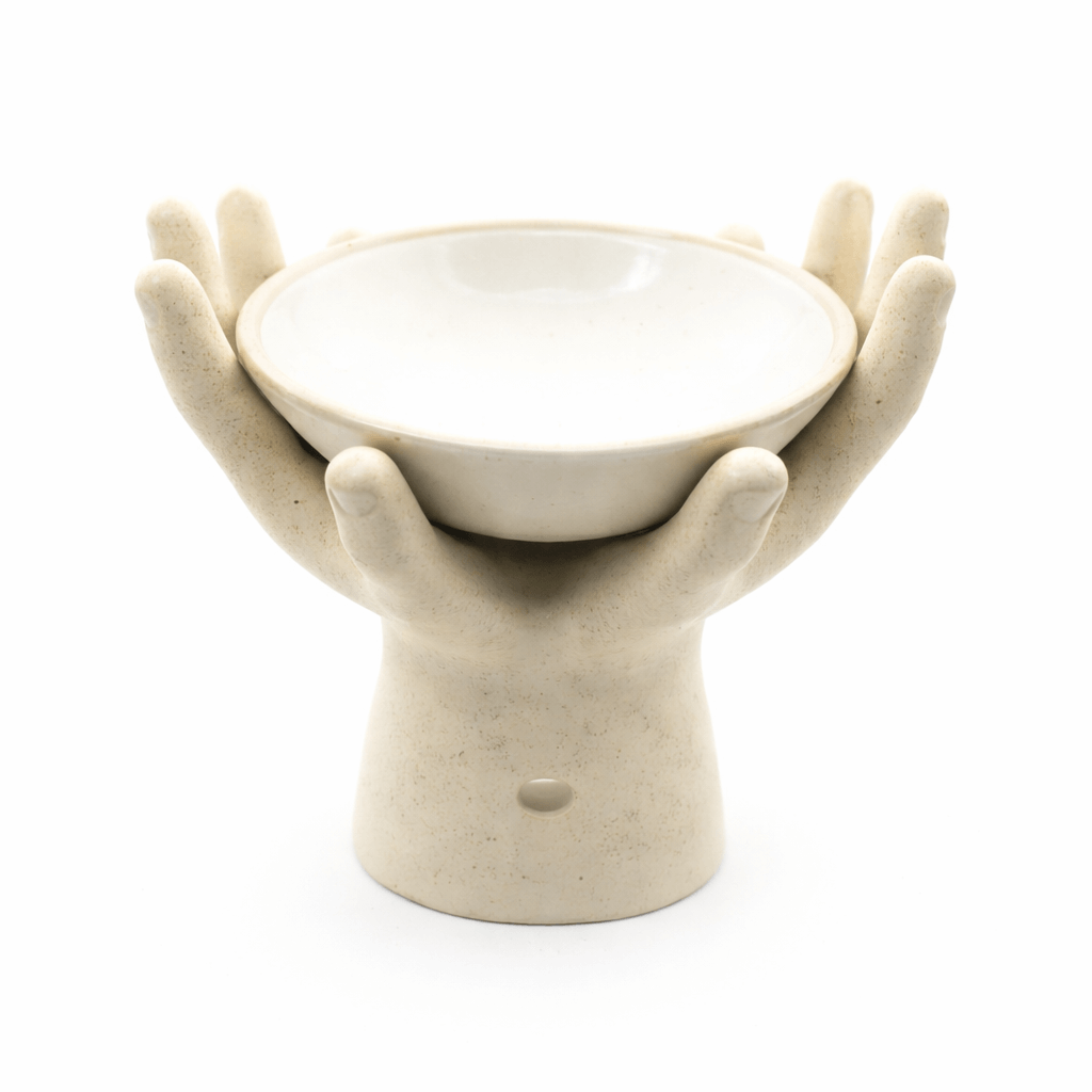 Crème keramieken aromabrander in handvorm met rond schaaltje bovenop, vrijstaand op witte achtergrond.