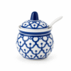 Blauw-wit Thais kruidenpotje van porselein met bijpassend deksel en wit lepeltje tegen een witte achtergrond.