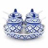 Thaise kruidenset met vier blauw-witte kruidenpotjes met deksels en lepeltjes op een bijpassende serveerschaal.