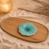 Blauw keramisch lotus bloembord van 16 cm op een houten dienblad in een warme sfeersetting.