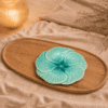 Blauw keramisch lotus bloembord van 20 cm op een houten dienblad in een sfeervolle warme setting.