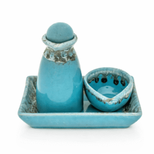 Turquoise keramische massage olie karaf met bijpassend schaaltje op een rechthoekig dienblad, vrijstaand op lichte achtergrond.