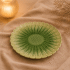 Groene keramische lotusschaal van 20 cm op beige stof in een warme sfeersetting met zachte verlichting.