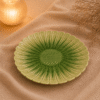 Groene keramische lotusschaal van 22 cm op beige stof in een warme sfeersetting met droogbloemen.