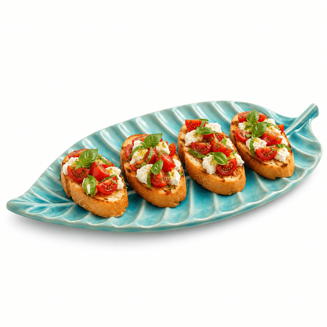 Blauwe keramische bladschaal met meerdere bruschetta’s met tomaat, mozzarella en basilicum op een witte achtergrond.