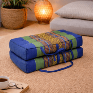 Opgevouwen Thais meditatiekussen in blauw en groen in een warme rustgevende interieursetting.