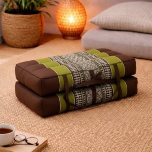 Opgevouwen Thais meditatiekussen in bruin en olijfgroen met licht traditioneel patroon in een warme en rustgevende interieursetting.