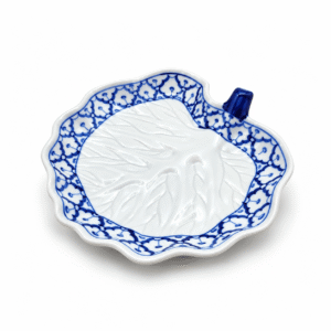 Blauw-wit Thais serveerblad in bladvorm met reliëf en traditioneel bloemmotief langs de rand.