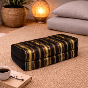 Rechthoekig Thais meditatiekussen met zwart-gouden silklook strepen in een warme en rustgevende interieursetting.