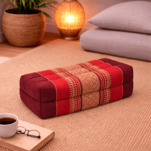 Rechthoekig Thais meditatiekussen in bordeauxrood met subtiel traditioneel patroon in een warme en sfeervolle interieursetting.