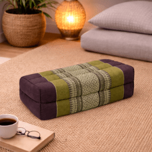 Rechthoekig Thais meditatiekussen in olijfgroen en bruin met traditioneel patroon in een warme interieursetting.