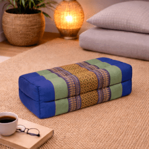 Rechthoekig Thais meditatiekussen in blauw en groen met goudkleurig traditioneel patroon in een warme interieursetting.