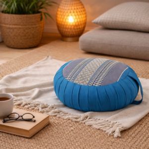 Rond Thais meditatiekussen in blauw en grijs met traditioneel patroon in een rustige, warme woonsetting.