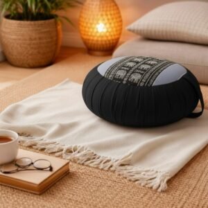 Rond Thais meditatiekussen in zwart en grijs met olifantpatroon op een plaid in een warm interieur.