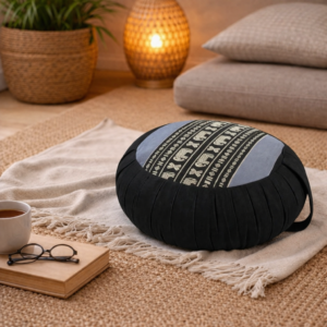 Rond Thais meditatiekussen in zwart en grijs met olifantpatroon op een plaid in een warm interieur.