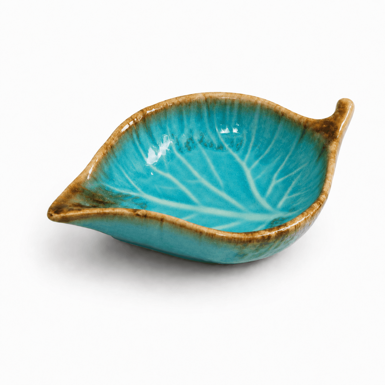 Turquoise crèmekleurig keramisch schaaltje in bladvorm met glanzend glazuur en bladnerf op witte achtergrond.