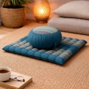 Blauw grijze zabutan mat met zafu meditatiekussen in warme woonkamer setting op kleed.