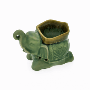 Groene keramieken olifant aromabrander met openingen aan de zijkant en een schaaltje bovenop, vrijstaand op witte achtergrond.