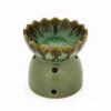 Groene keramische aromabrander met lotusvormig schaaltje en ronde ventilatiegaten, vrijstaand op witte achtergrond.