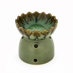 Groene keramische aromabrander met lotusvormig schaaltje en ronde ventilatiegaten, vrijstaand op witte achtergrond.