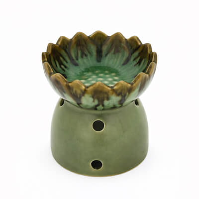 Groene keramische aromabrander met lotusvormig schaaltje en ronde ventilatiegaten, vrijstaand op witte achtergrond.