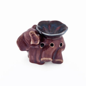 Paarse keramische aromabrander in olifantvorm met donkerblauw schaaltje bovenop en ventilatiegaten, vrijstaand op witte achtergrond.