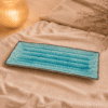 Blauwe rechthoekige keramische serveerschaal van 29 cm op beige stof in een warme sfeersetting.
