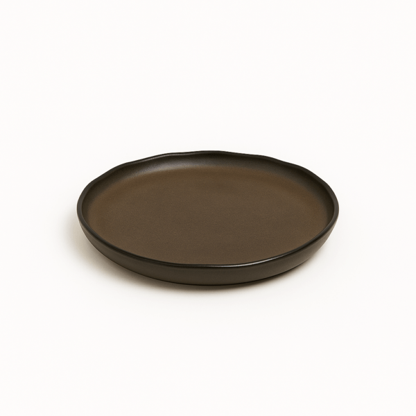 Rond bord van 24 cm in bruin keramiek, met organisch golvende rand – bovenaanzicht.