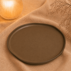 Diep bord mat bruin 29 cm op een warme stoffen ondergrond met zachte verlichting en natuurlijke decoratie.