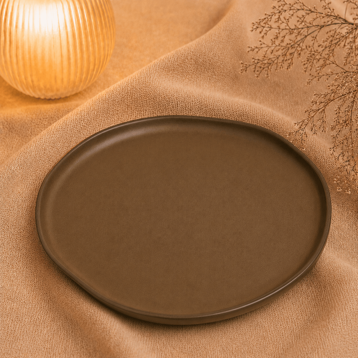 Diep bord mat bruin 29 cm op een warme stoffen ondergrond met zachte verlichting en natuurlijke decoratie.