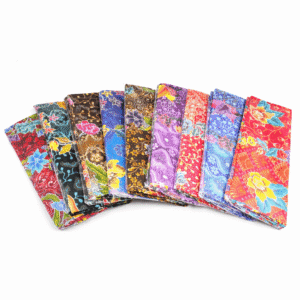 Assortiment sarong batik doeken in diverse kleuren en bloemdessins, gevouwen en waaiervormig gepresenteerd op een lichte achtergrond.