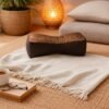 Bruin-goud Thais bone meditatiekussen met sierlijk patroon in een warm en stijlvol yoga-interieur.