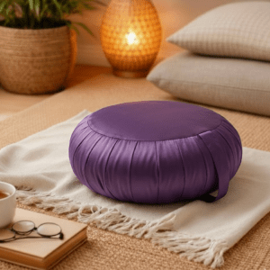 Rond Thais zafu kussen in effen lila op een lichte plaid in een warme en rustige ruimte.