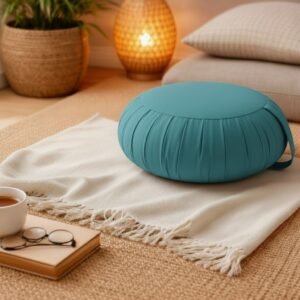 Rond Thais zafu kussen in effen turquoise op een lichte plaid in een rustige en sfeervolle kamer.