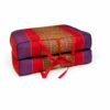 Opvouwbaar meditatiekussen rood-paars, compact opgevouwen met draaglinten zichtbaar.