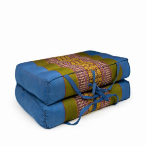 Draagbaar meditatiekussen blauw-groen met handgeweven patroon, opgevouwen en vastgebonden met draaglinten.