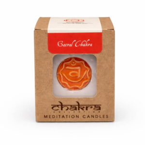 Sacral Chakra meditatiekaars in kartonnen verpakking met oranje chakra-symbool, vrijstaand op witte achtergrond voor webshop hoofdfoto.