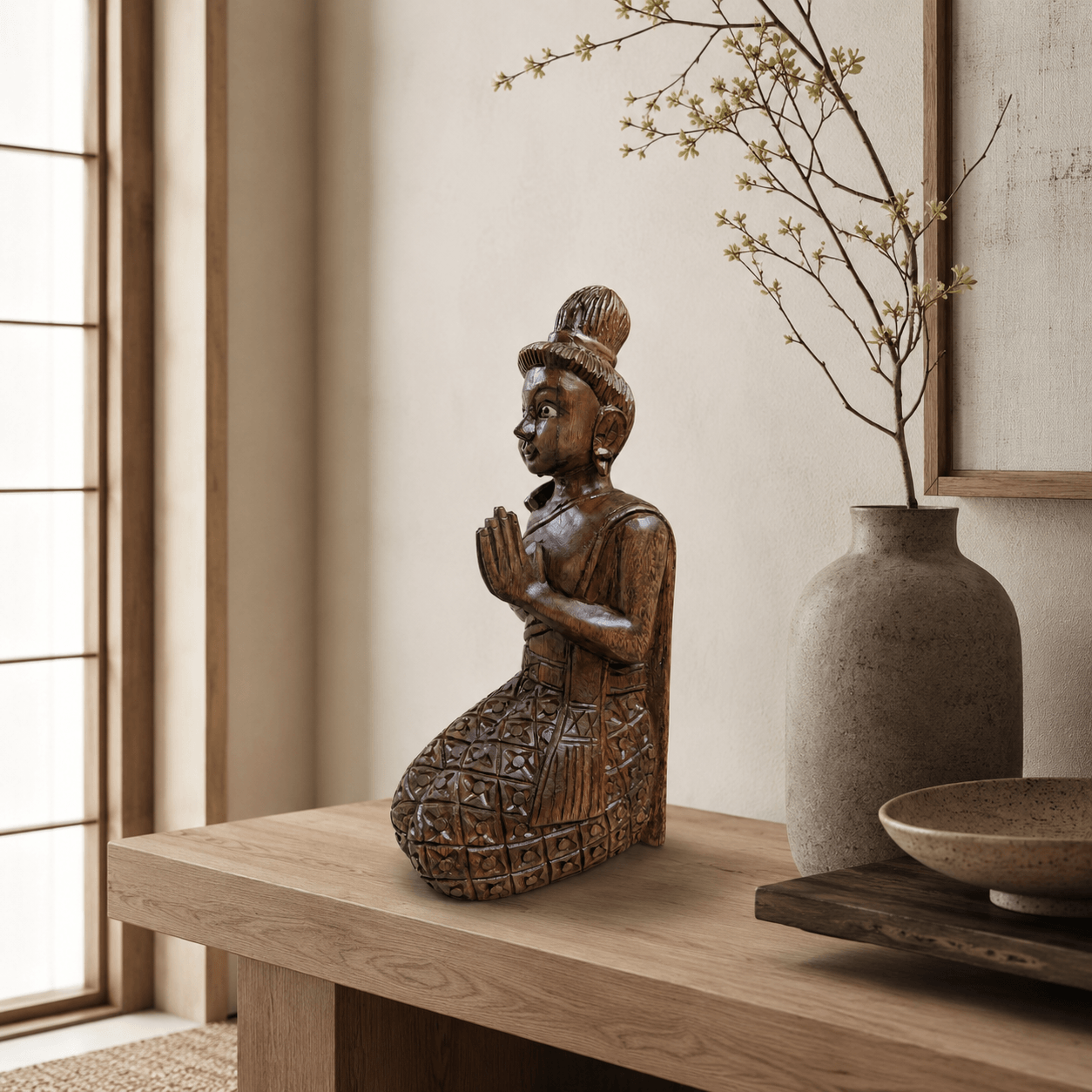 Bruin houten Sawadee Lady beeld als rustige woondecoratie in Japandi stijl op een houten tafel met vaas en takken.