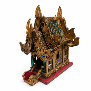 Thaise tempelhuis goud groot vanuit schuin zijaanzicht met gouden tempeldetails, gekleurde decoratie en rode basis.