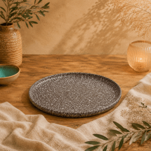 Bruin-wit gespikkeld plat bord van 25,5 cm op een houten tafel met warme natuurlijke styling.