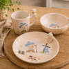 Kinderservies Knorri met mok, kom en bord op houten tafel in een warme sfeeropstelling.