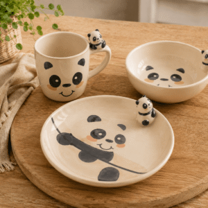 Kinderservies Pandi met mok, kom en bord op houten tafel in een warme sfeeropstelling.