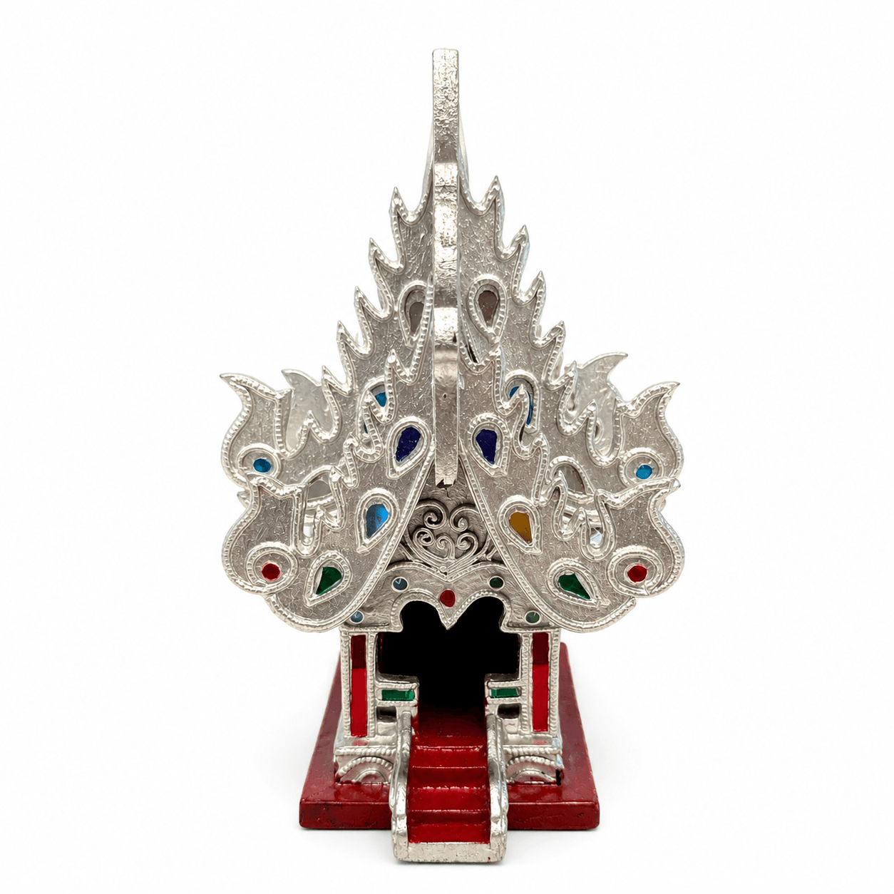 Zilverkleurig Thais tempelhuis met dubbeldak, rode basis en gekleurde decoratieve details op een witte achtergrond.