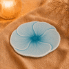 Blauw bloembord Lotus van 22 cm, sfeervol gepresenteerd op beige stof.