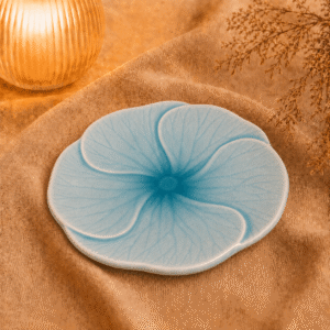 Blauw bloembord Lotus van 22 cm, sfeervol gepresenteerd op beige stof.