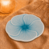 Blauw bloembord Lotus van 25 cm, sfeervol gepresenteerd op beige stof.