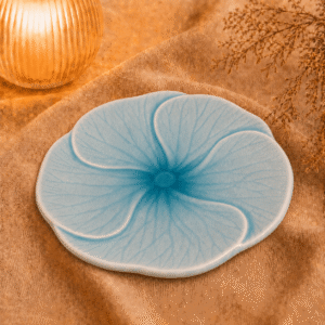 Blauw bloembord Lotus van 25 cm, sfeervol gepresenteerd op beige stof.