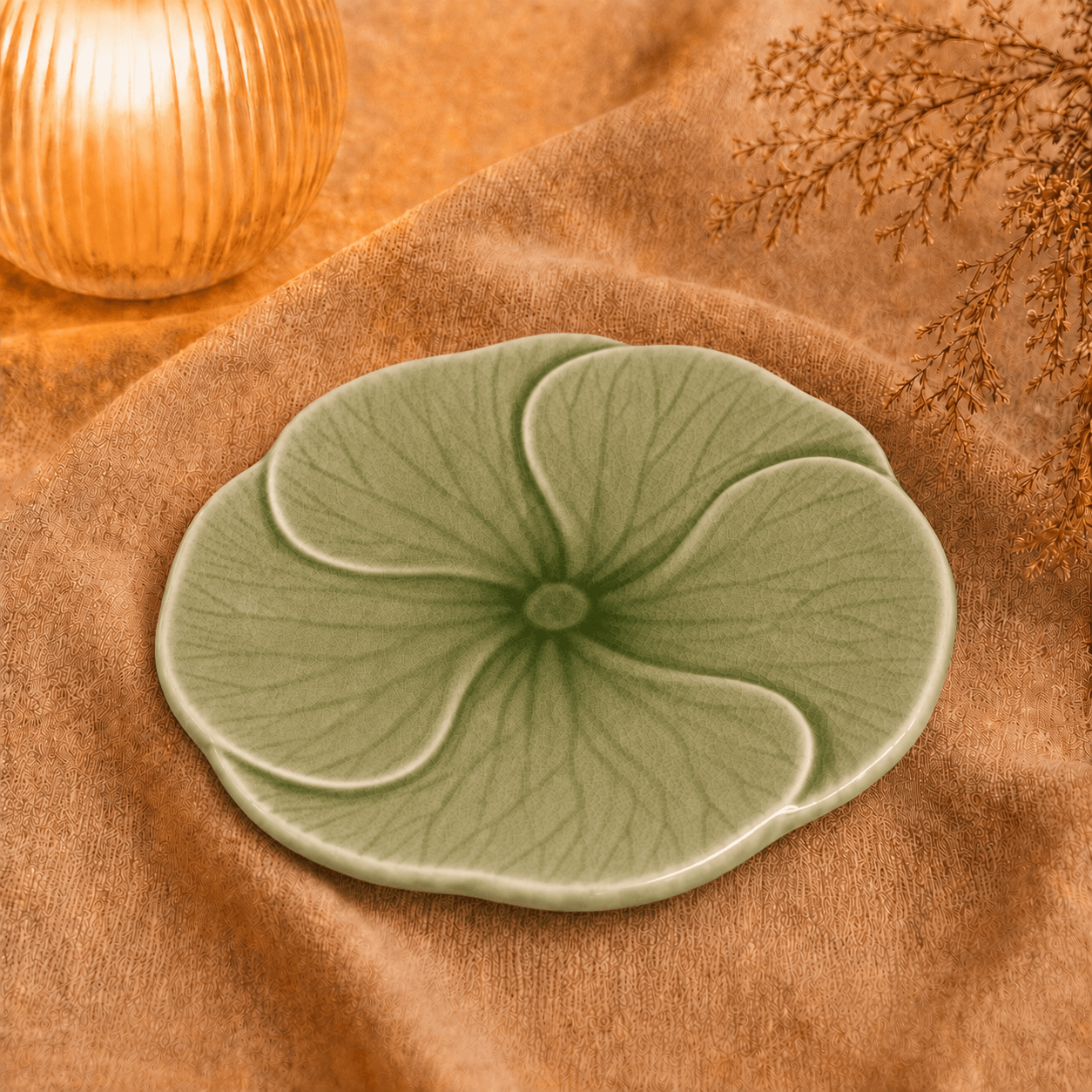 Groen bloembord Lotus van 22 cm, sfeervol gepresenteerd op beige stof met warme verlichting.