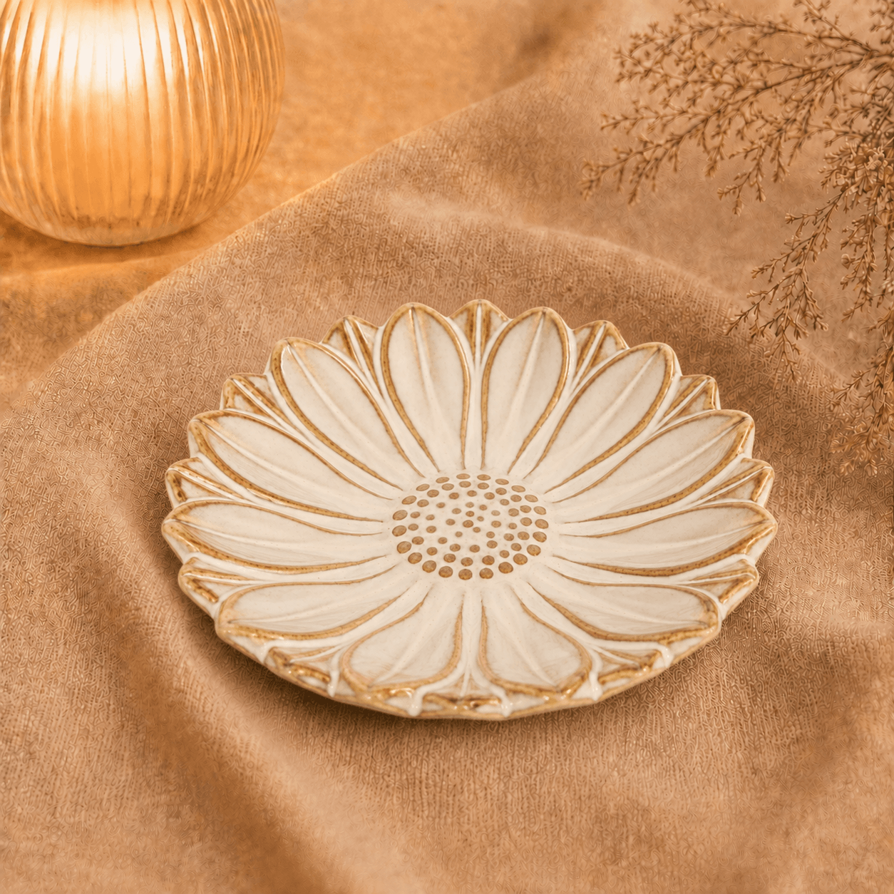 Créme-bruin bloemenschaaltje van 13 cm, sfeervol gepresenteerd op beige textiel bij warme verlichting en droogbloemen.